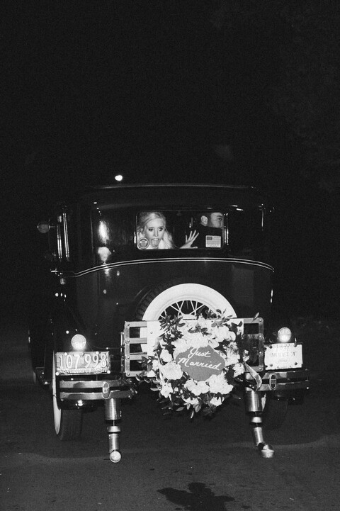 bride and groom exit on a vintage car