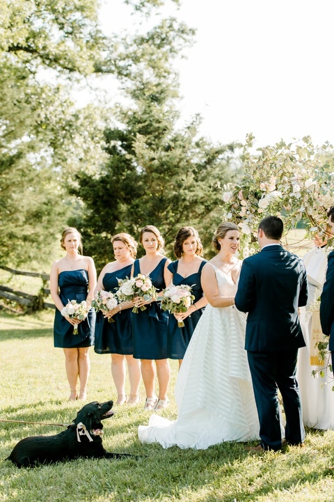 Outdoor farm wedding with a dog in Richmond VA coordinated by Make It Posh Events. Flowers by Petals and Twigs. Hayley Paige striped dress. Photo by Caroline Lima.