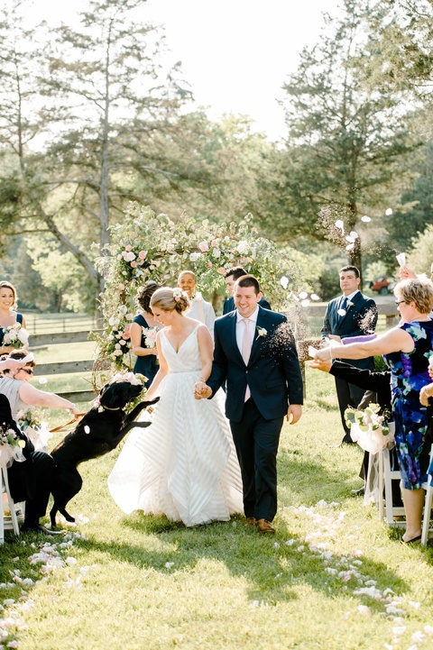 Outdoor farm wedding with a dog in Richmond VA coordinated by Make It Posh Events. Flowers by Petals and Twigs. Hayley Paige striped dress. Photo by Caroline Lima.