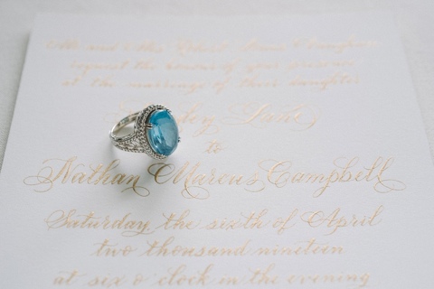 Emerald engagement ring on a calligraphy wedding invitation at The Argyle in San Antonio