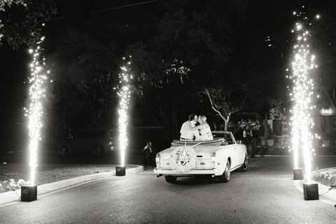 Bride and groom exiting on a vintage car surrounded by fireworks at the Argyle in San Antonio. 